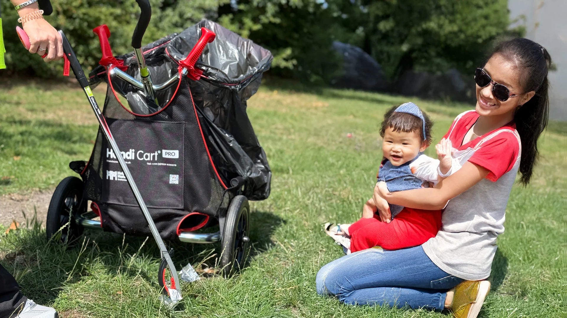 Family sitting on grass next to a Litter Picker Handi Cart.