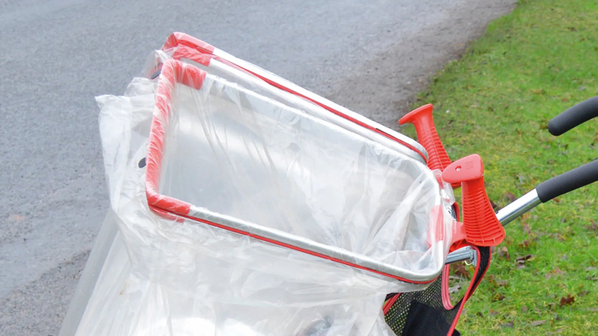 Handi Cart Pro Cleaning Trolley with a white plastic bag attached on a grassy area.