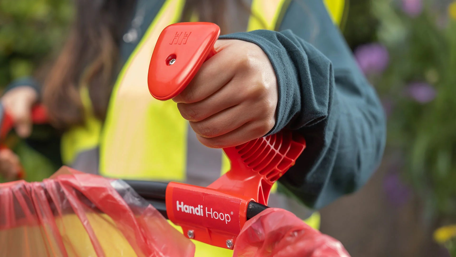 Person holding a Handi Hoop Handle with blurred background.