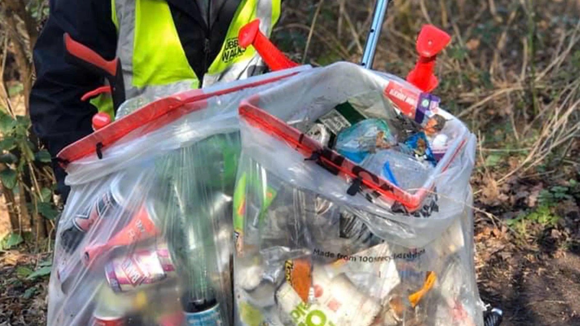 Person collecting litter outdoors in the Handi Cart Pro.