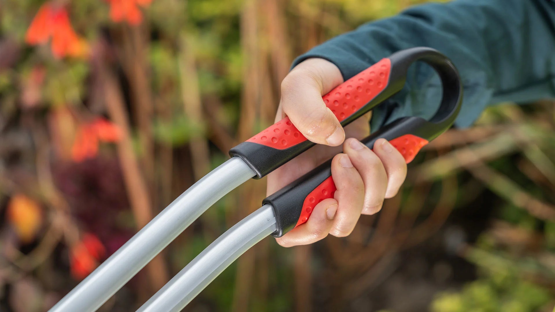 Person holding a Ranger Max curved handle against a blurred natural background.