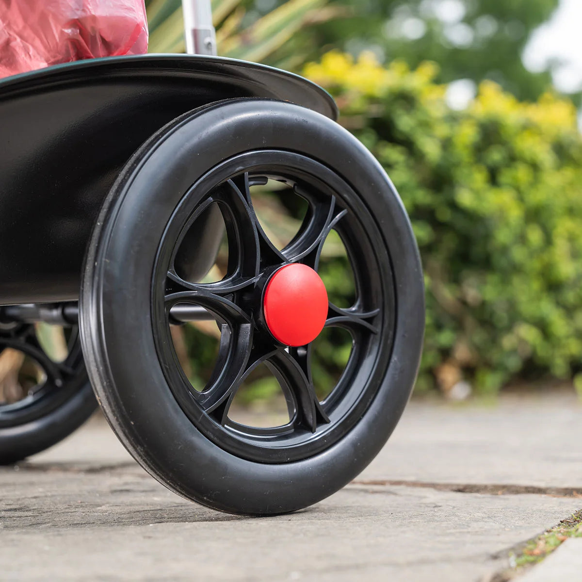 Close-up of Handi Cart Lite litter trolley with blurred greenery in the background