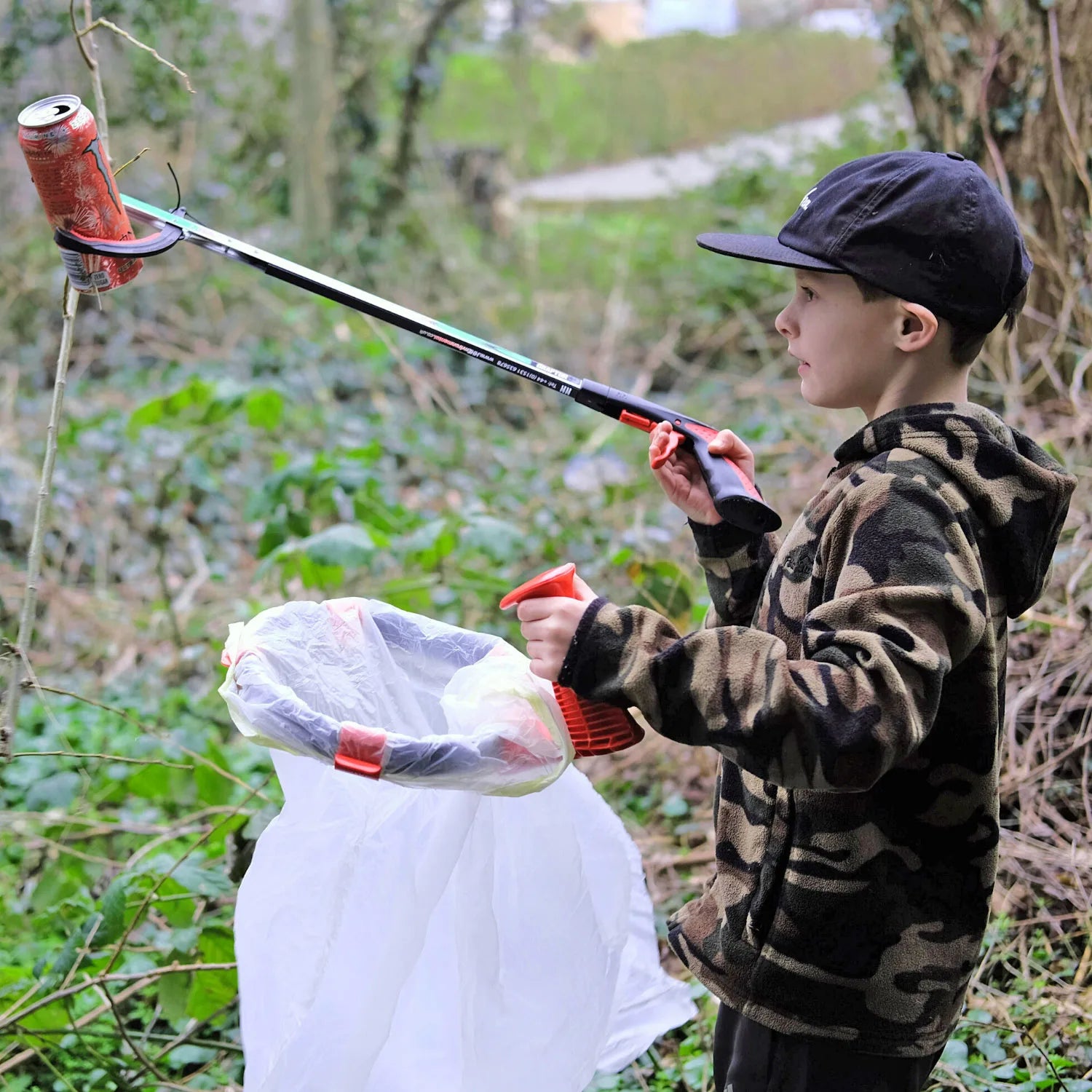 Child picking up litter outdoors with Kids litter picker and Handi Hoop Kids.