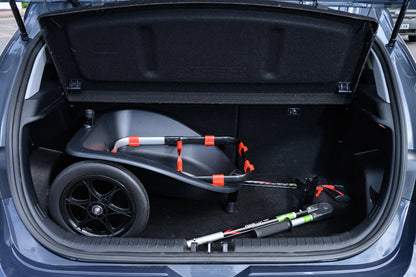 Trunk of a car with a folded litter cart inside