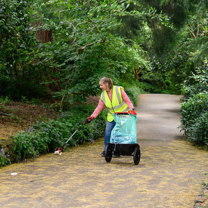 Someone picking up litter on a path using a litter picker and a cart
