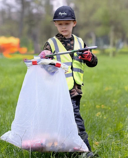 Child picking litter with litter bag hoop.