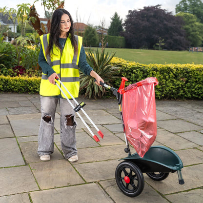 Volunteer in a yellow safety vest using Handi Cart Lite outside with grabber tool.