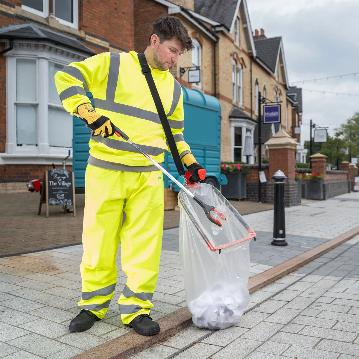 Person cleaning up on a street using a litter picker and Handi Hoop Plus Litter Hoop.