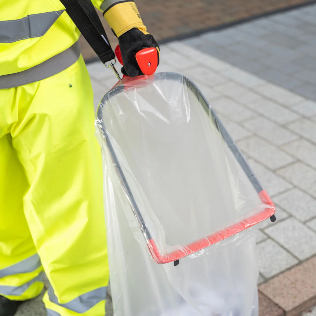 Person in high-visibility clothing using a Handi Hoop Plus Litter Hoop.