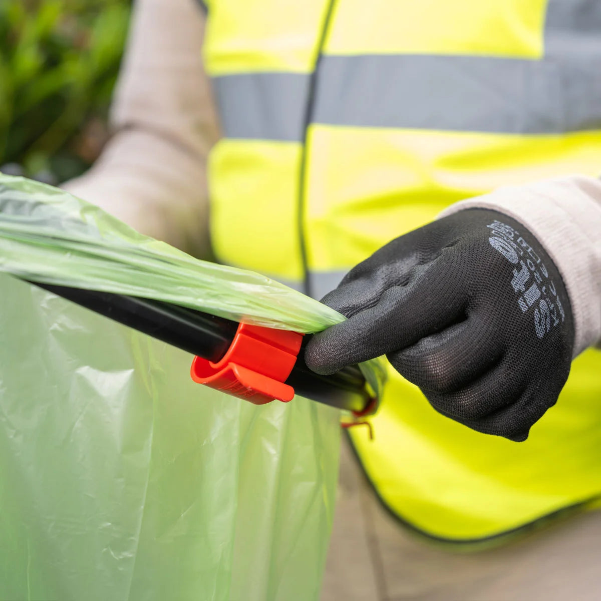 Volunteer in a Hi Vis pulling bag over Handi Hoop Pro Clip Litter Hoop.