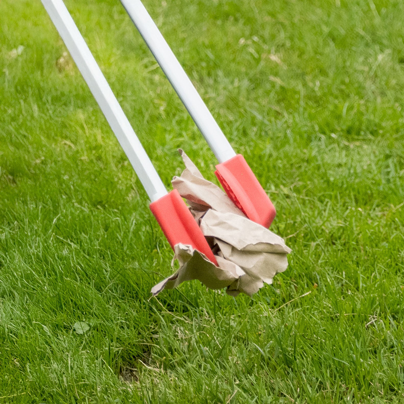 Ranger Max litter picking grabbing paper trash on field.