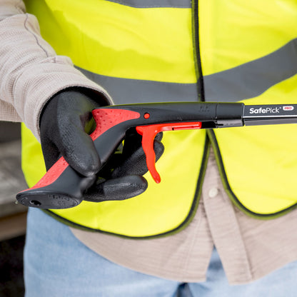 Person wearing a high-visibility jacket holding SafePick Pro litter picker handle.
